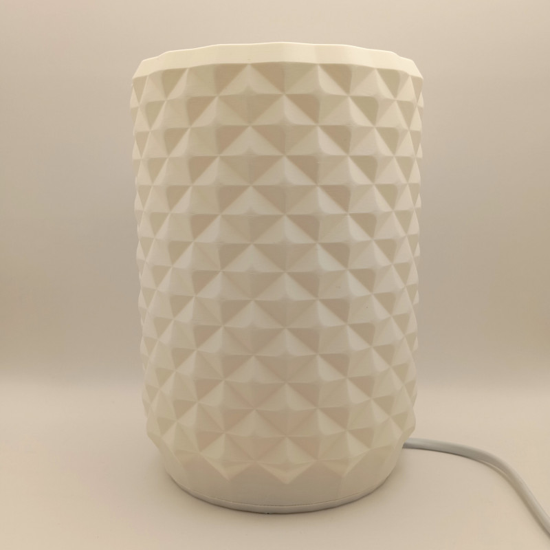 Une lampe cylindrique texturée, un bijou de lumière pour un intérieur moderne et chaleureux.