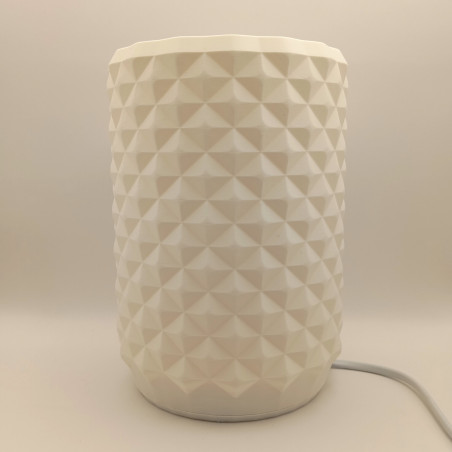 Une lampe cylindrique texturée, un bijou de lumière pour un intérieur moderne et chaleureux.
