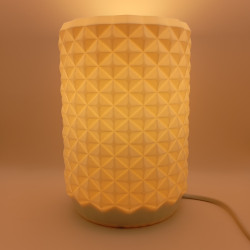 Une lampe cylindrique texturée, un bijou de lumière pour un intérieur moderne et chaleureux.